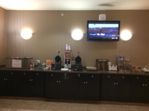 a room with a bar with a tv on the wall at Super 8 by Wyndham Edson in Edson