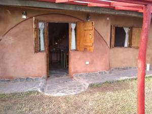 una entrada a una casa con puerta y ventanas en Alojamiento Ecológico Kurache en Tandil