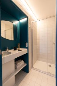a bathroom with a sink and a shower at HOTEL LEHOUCK in Koksijde