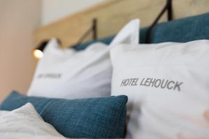 a bed with pillows and pillows on it at HOTEL LEHOUCK in Koksijde
