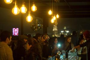 un gruppo di persone seduti in un bar con luci di Hostel Mundo Joven Catedral a Città del Messico