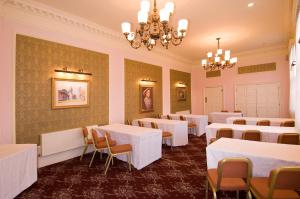 a dining room with tables and chairs and a chandelier at George & Pilgrims Hotel in Glastonbury