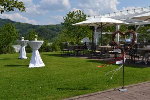 einen Garten mit Tischen, Stühlen und einem Sonnenschirm in der Unterkunft Hotel Die Alm in Oberkirch