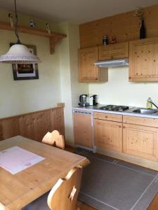 a kitchen with wooden cabinets and a wooden table at Eisenhut Suite 3 in Turracher Hohe