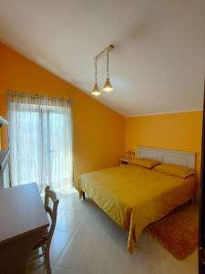 Dormitorio amarillo con cama y ventana en DA ELENA, en Castel di Sangro