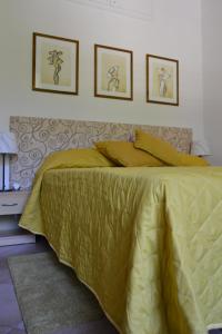 un letto in una camera da letto con due immagini sul muro di Le Tre Sorelle a Testaccio a Roma