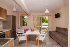 a kitchen and living room with a white table and chairs at Nefeli in Vasiliki