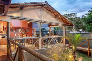 a house with large glass windows and a patio at Pousada Makutta in Lavras Novas