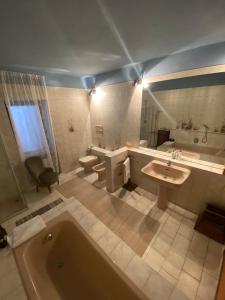 ein Badezimmer mit einer Badewanne, einem Waschbecken und einem WC in der Unterkunft MAMOTA B&B in Vesime