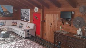 ein Wohnzimmer mit einem Sofa und einem TV in der Unterkunft BeB Villa Sorriso in San Benedetto Val di Sambro