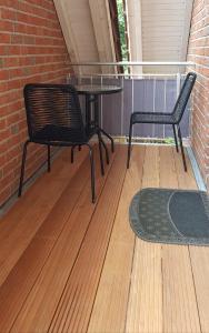 a patio with two chairs and a table and a rug at Haus am Bürgerpark Hage OG in Hage +2 photos