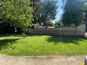 a yard with a retaining wall and a tree at The Georgian Manor Apartment - Central Frome in Frome