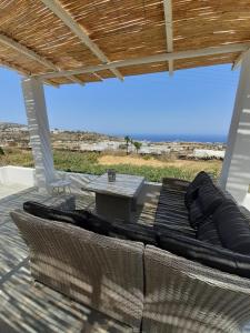 a covered patio with a couch and a table at ViewLight Sifnos Living in Apollonia