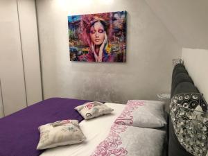 a bedroom with a bed with a painting on the wall at Apartment Vid in Split