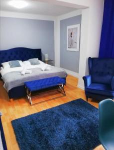 1 dormitorio con 1 cama azul y 1 silla azul en Great Polonia Strzegom City Center, en Strzegom