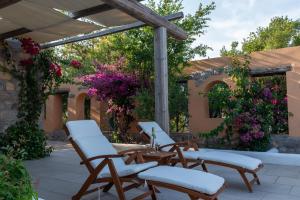 a patio with three chairs and a pergola at Blue Vista Patmos pool studio in Patmos