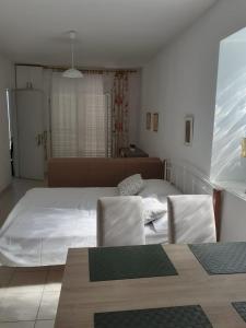 um quarto com uma cama, 2 cadeiras e uma mesa em Sobe Zeneral em Novalja