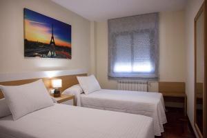 ビジャルバにあるLaros Pios Alojamiento 1のベッド2台と窓が備わるホテルルームです。