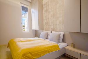 1 dormitorio con 1 cama con sábanas amarillas y ventana en MF Casa Galerius Apartment, en Siófok