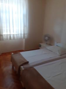 um quarto com 2 camas e uma janela em Sobe Zeneral em Novalja