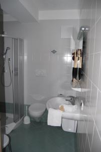 La salle de bains blanche est pourvue de toilettes et d'un lavabo. dans l'établissement Residence Ciasa Alpe, à Vigo di Fassa