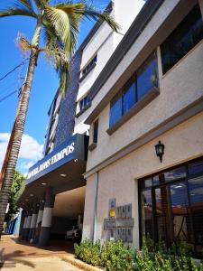 a building with a palm tree in front of it at Hotel Bons Tempos in Rio Verde