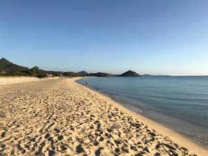 uma praia com pegadas na areia e na água em Villa Antonella em Villasimius