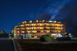 a tall building with lights on it at night at Свети Зосим in Sozopol
