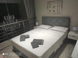 a bedroom with a white bed with two crosses on it at Kamares suites in Nea Kallikrateia