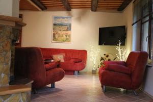 ein Wohnzimmer mit roten Sofas und einem Flachbild-TV in der Unterkunft Domček v záhrade in Liptovský Hrádok