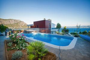 ein Pool vor einem Haus in der Unterkunft Villa Sara with Sea View and Private Heated Pool in Omiš