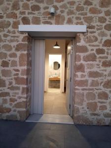 una porta per entrare in una stanza con un muro di mattoni di en lefko a Lefkos Karpathou