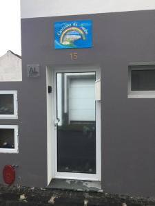 a grey building with a door with a sign on it at Cantinho do Sonho in Maia