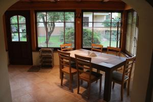 a dining room with a table and chairs and windows at Domček v záhrade in Liptovský Hrádok