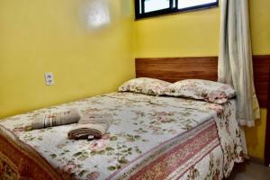 a bedroom with a bed with a blanket on it at Pousada do Turista in Fortaleza