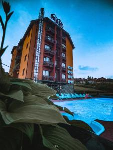 un edificio con piscina en frente de un edificio en Alpin Hotel, en Bukovel