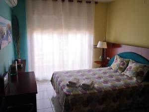 a bedroom with a bed and a desk and a window at Villa Tito in Cunit