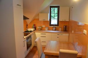 a kitchen with a wooden table and a dining room at Agroturystyka Leśny Potok in Fredropol