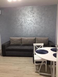 sala de estar con sofá negro y mesa en Mirror Lake Apartment, en Mamaia