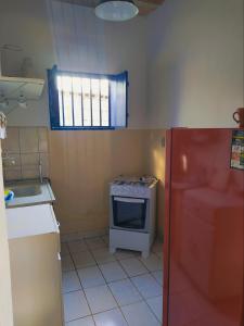 a small kitchen with a stove and a window at Hospedaria Villa Mariana in Santo Antônio do Leite