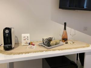 un tavolo con macchinetta del caffè e una bottiglia di vino di Le Calette 105 ad Alghero