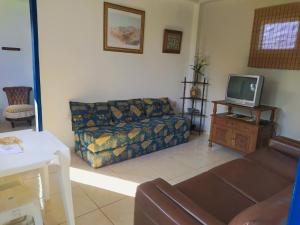a living room with a couch and a tv at Hospedaria Villa Mariana in Santo Antônio do Leite