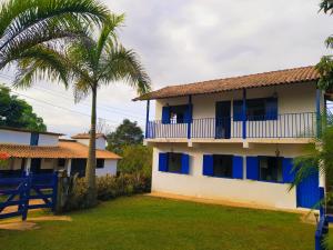 un edificio con finestre blu e una palma di Hospedaria Villa Mariana a Santo Antônio do Leite