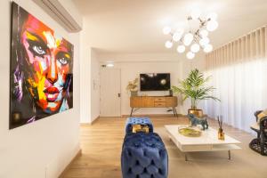 a living room with a painting of a woman at Barra Apartament Design in Gafanha da Nazaré