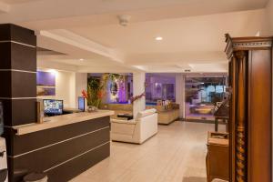 a lobby with a reception desk and a living room at Aqua Granada Hotel in Cali