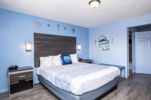 een slaapkamer met een groot bed en een blauwe muur bij Aqua Breeze Inn in Santa Cruz