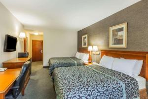 Habitación de hotel con 2 camas y escritorio en Days Inn by Wyndham Budd Lake, en Budd Lake
