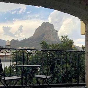a balcony with a table and chairs and a mountain at Hotel Don Faustino in Bernal