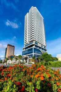 Um edifício alto com um ramo de flores à frente. em DeLaSea Ha Long Hotel em Ha Long
