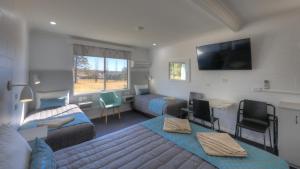 a bedroom with a bed and a living room at Glen Innes Motel in Glen Innes